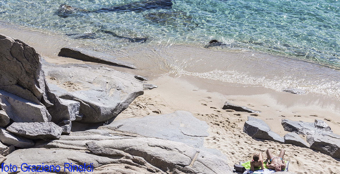 Rocks, sand and clear water on Elba island